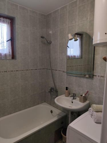 a bathroom with a bath tub and a sink and a bath tub at Butmir house-Sarajevo in Sarajevo