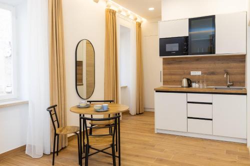 una pequeña cocina con mesa y espejo en Soleil Palace, en Dubrovnik