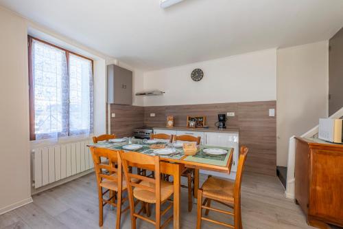 - une cuisine avec une table à manger et des chaises dans l'établissement Le Gîte de la Passerelle - avec jacuzzi, à Saint-Clair-sur-Galaure