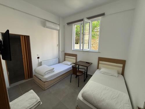 a room with two beds and a table with a television at FAMİLY PLAs HOME in Edirne
