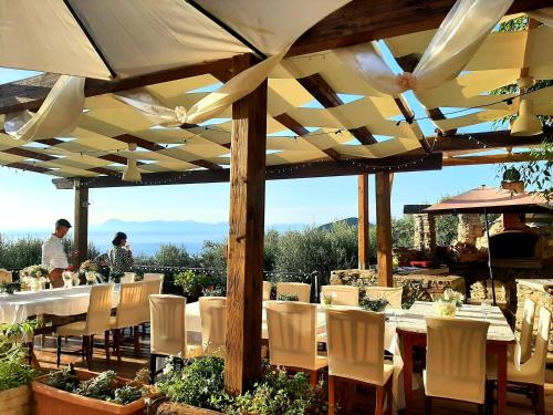 a restaurant with tables and chairs under a roof at Dimora Acqua del Fico in Castellabate