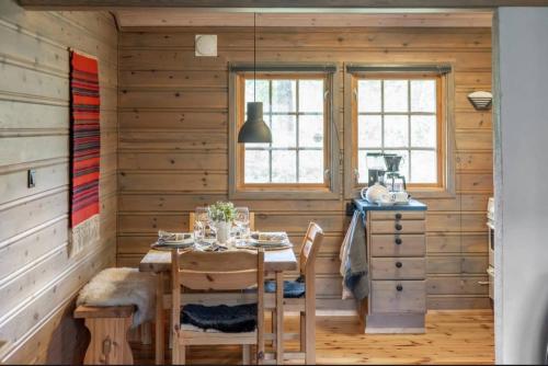 a dining room with a table in a wooden house at Guest favorite - 5 mins from Vøringsfossen in Garden