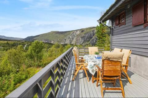 a table and chairs on a deck with a view at Guest favorite - 5 mins from Vøringsfossen in Garden
