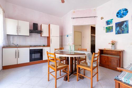 a kitchen with a table and chairs in a room at Casa Loretta 3 in Valledoria