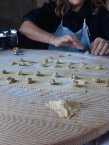 a woman sitting at a table with dumpling ingredients at Dimora Acqua del Fico in Castellabate