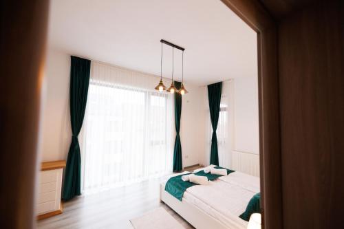 a bedroom with a bed and a large window at Thyon Apartments in Sebeş