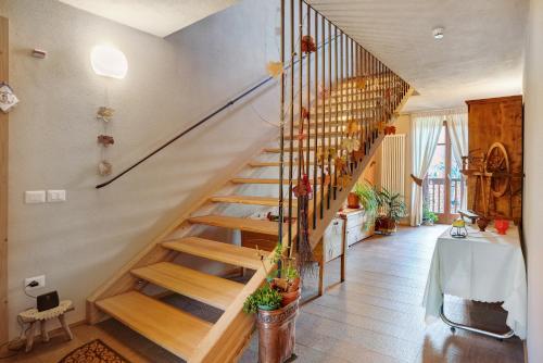 a wooden staircase in a room with a table at Agritur La Gemma in Sant'Orsola Terme
