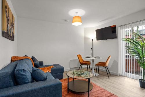 un salon avec un canapé bleu et une table dans l'établissement Charming 1 BR apartment walk to city centre, à Belfast
