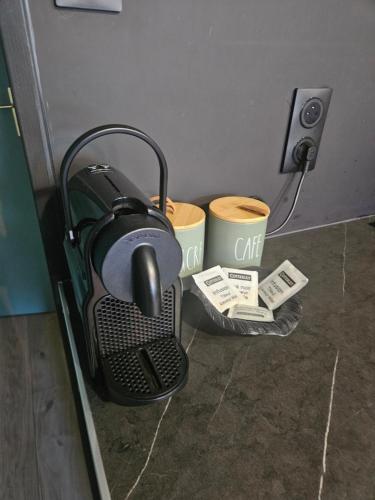 a coffee maker sitting on the floor in a room at The 8 in Lunéville