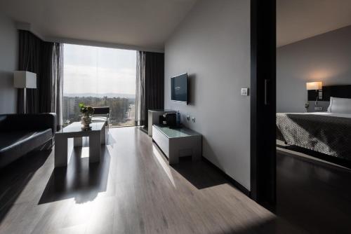 a hotel room with a bed and a desk with a television at Eurostars Palace in Córdoba