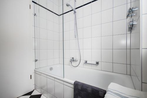 a white bathroom with a tub and a shower at Ferienwohnung Bernhardt in Lindau