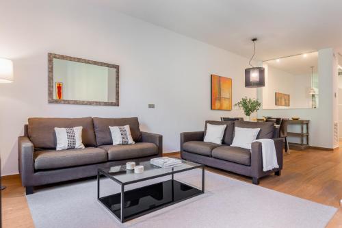 a living room with two couches and a table at Aspasios Rambla Catalunya Apartments in Barcelona
