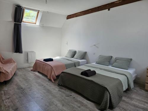 a room with two beds and a window at Chambres d'hôtes Provins in Poigny