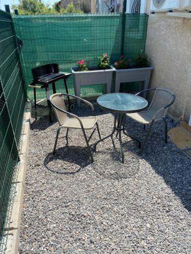 three chairs and a table and a table and chairs at Appart 2 pièces in Canaules-et-Argentières