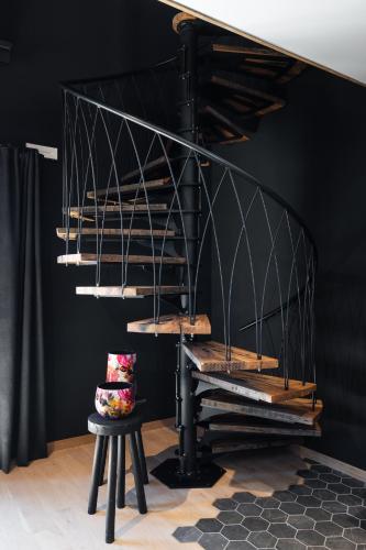 a black living room with a black staircase and a stool at Suite Zen By M in Francorchamps