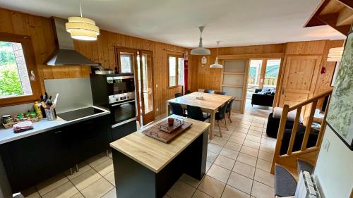 une cuisine avec une table et un comptoir dans l'établissement Chalet Le Salers 10pers Le Mont Dore, à Mont-Dore