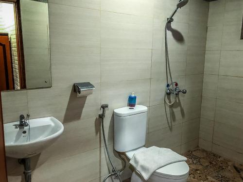a bathroom with a shower and a toilet and a sink at Arys Garden Hotel Yogyakarta in Yogyakarta
