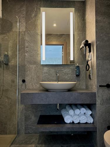 a bathroom with a sink and a mirror and towels at Lake Hill Karkonosze Apartments in Sosnówka