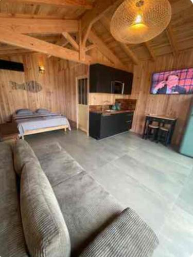 un salon avec un canapé et un lit dans l'établissement Cabane esprit Bassin à 100 mètres de la plage, à Arès