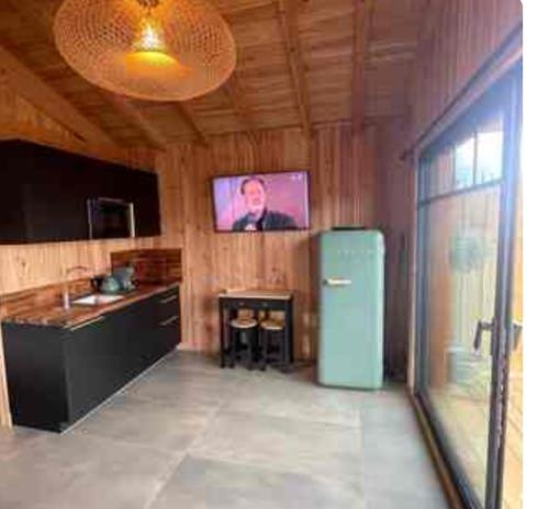 Il comprend une cuisine équipée d'un réfrigérateur et une télévision murale. dans l'établissement Cabane esprit Bassin à 100 mètres de la plage, à Arès