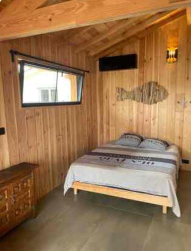 une chambre avec un lit dans une cabane en bois dans l'établissement Cabane esprit Bassin à 100 mètres de la plage, à Arès