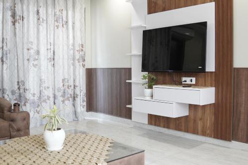 un soggiorno con una TV a parete di Staybia Hotel and Service Apartments, Sector-27, Noida a Noida