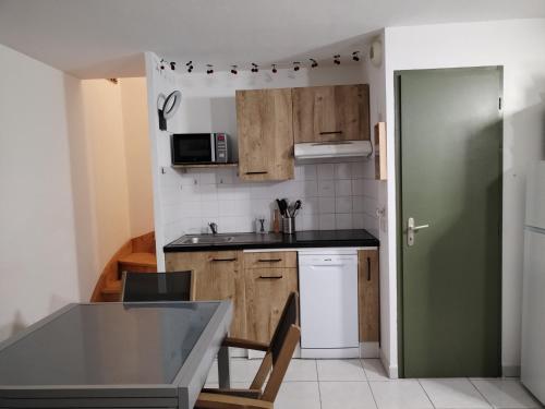 une cuisine avec des placards en bois et une porte verte dans l'établissement Maison de vacances à Torreilles, à Torreilles