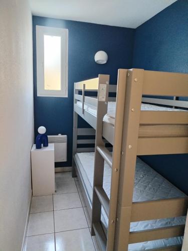 une chambre avec deux lits superposés et une fenêtre dans l'établissement Maison de vacances à Torreilles, à Torreilles