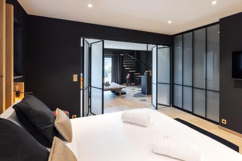 a bedroom with a white bed and a black wall at Suite Zen By M in Francorchamps