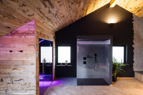 a bathroom with a glass shower with purple lighting at Suite Zen By M in Francorchamps