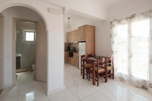 a kitchen and dining room with a table and chairs at Rainbow in Arillas