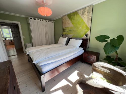 a bedroom with a bed with a painting on the wall at Deluxe Hotel Apartment in Charlottenlund