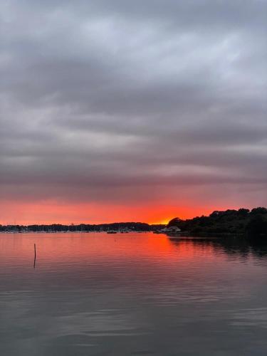 un coucher de soleil sur une grande étendue d'eau dans l'établissement Location logement entier Maison bourg, proche plages, Arradon - Morbihan, à Arradon
