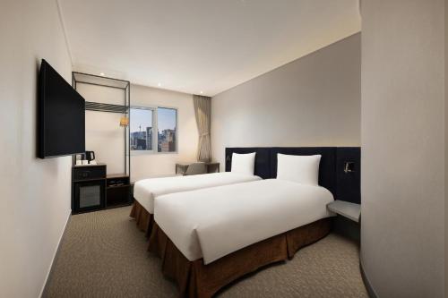 ソウルにあるibis Ambassador Seoul Insadong-Newly renovated in 2025のベッド2台とテレビがあるホテルの部屋