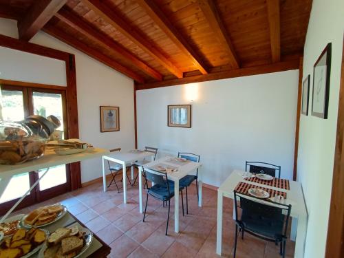 a kitchen with tables and chairs in a room at B&b Il Leccio in Subiaco