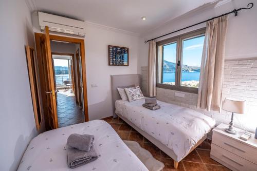 a bedroom with two beds and a window at Cala Agulla 1 in Cala Ratjada