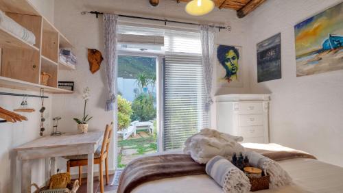 a bedroom with a bed and a large window at Klein-Hangklip Remote Mountain Studio Cottage in Rooiels