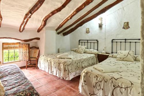 ein Schlafzimmer mit zwei Betten und einem Fenster in der Unterkunft Cortijo Rural Majolero 1 in Castillo de Locubín
