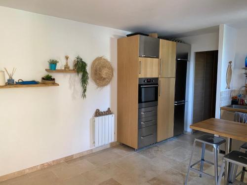 Il comprend une cuisine équipée d'un réfrigérateur et d'une table. dans l'établissement studio avec grand jardin, à La Ciotat