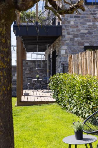 a patio with chairs and a table in a yard at Suite Cocoon By M in Francorchamps