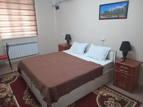 1 dormitorio con 1 cama con 2 almohadas y mesa en Full apartment in city center, en Khiva