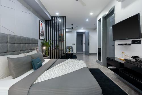 a bedroom with a large bed and a flat screen tv at BedChambers Luxurious Serviced Apartment in Gurgaon in Gurgaon