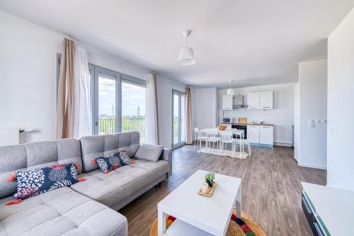 un salon avec un canapé et une table dans l'établissement Les Doux Épis - appt proche gare RER, à Cergy