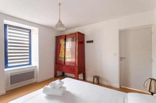 a bedroom with a bed and a dresser and a window at La Pause Bohème - A quelques minutes de la plage in Pléneuf-Val-André