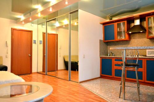 サラトフにあるКвартира студия на ул Волжская в центре рядом с Волгойのキッチン(青いキャビネット、テーブル、椅子付)