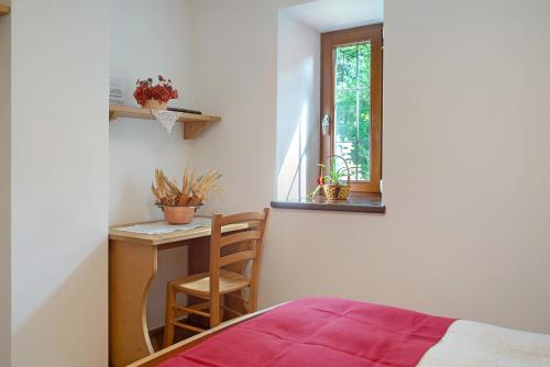 a bedroom with a desk and a bed and a window at Agritur La Gemma in Sant'Orsola Terme