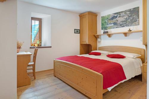 a bedroom with a large bed with a red blanket at Agritur La Gemma in Sant'Orsola Terme