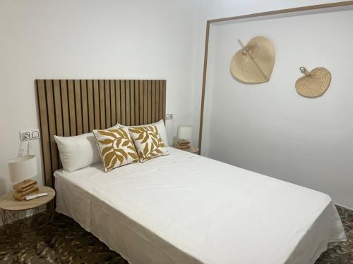 ein Schlafzimmer mit einem großen weißen Bett mit zwei Kissen in der Unterkunft Amplio apartamento cerca al mar in Puerto de Sagunto