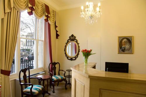 a dining room with a table and chairs and a window at Rose Park Hotel in London