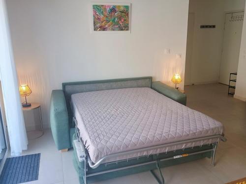 - un lit dans une pièce avec deux lampes dans l'établissement AYAPI - Appartement neuf 3 étoiles avec terrasse et jardin - bord de plage, à Marseillan